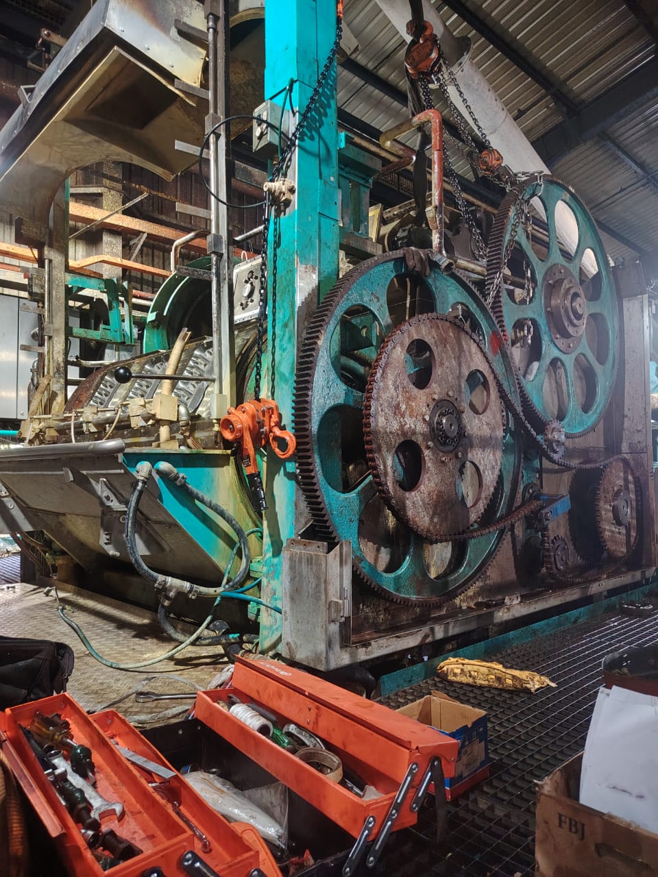 Teal gear and chain drive on a large drum machine
